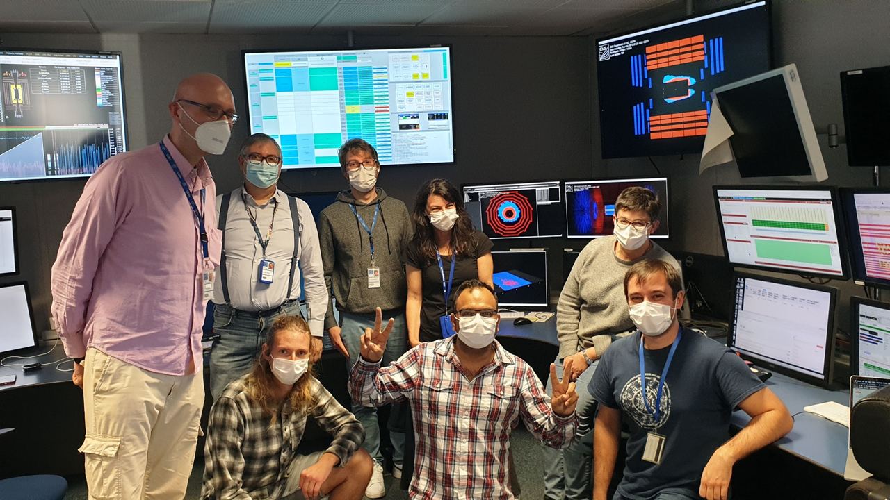 Happy mask-covered CMS physicists’ faces after the first beam splash at the CMS control room. Credits: G. Boudoul